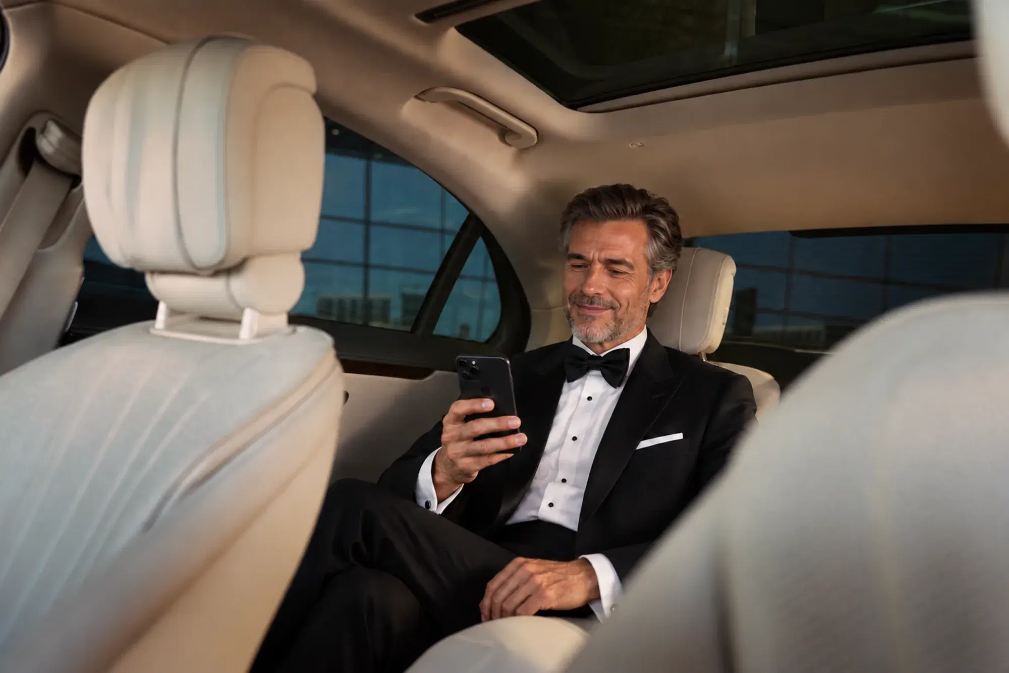 Passenger booking a ride from the back seat of a luxury vehicle